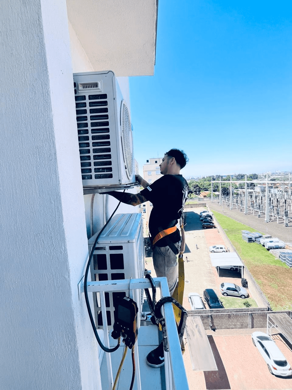 Técnico GS realizando instalação de ar-condicionado em fachada
